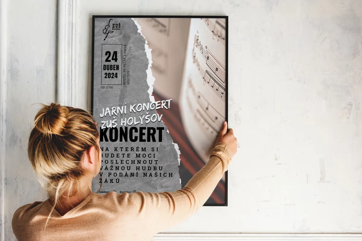 Koncertní plakát s portrétem a typografií umístěný na světlé stěně